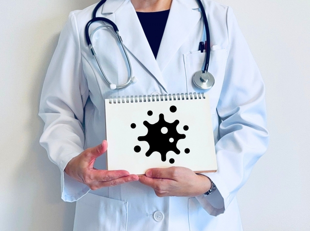 ウイルスの絵が描かれたノートを持つ医師